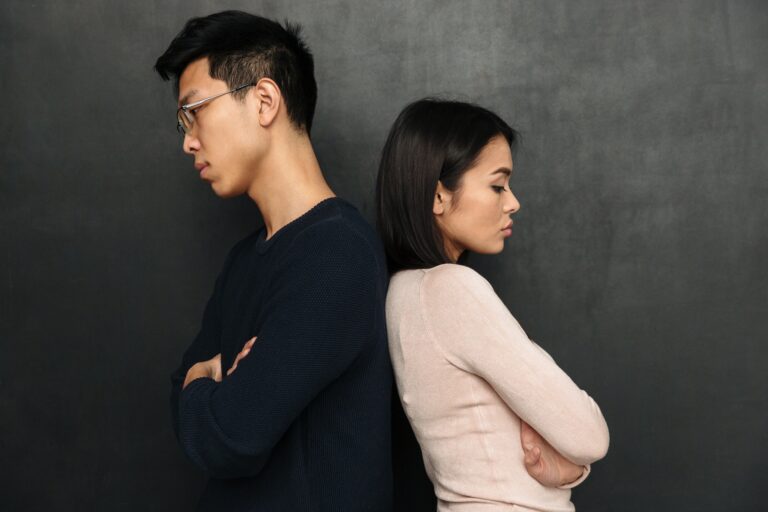 Side view of Offended couple standing back to each other